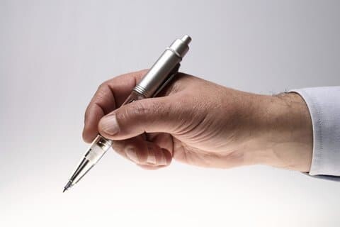 This ballpoint pen in a man's hand symbolizes the fiction manuscript writing and editing process.