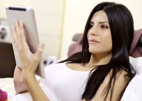 This young woman is relaxing and reading an ebook that we had ghostwritten, on her iPad.